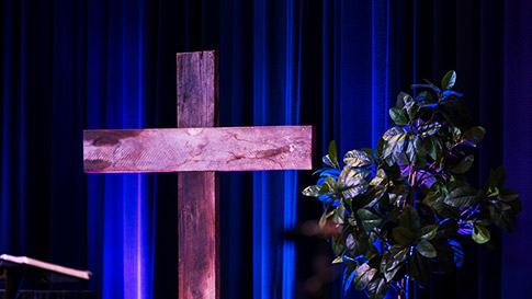 Wooden Cross on stage with plant